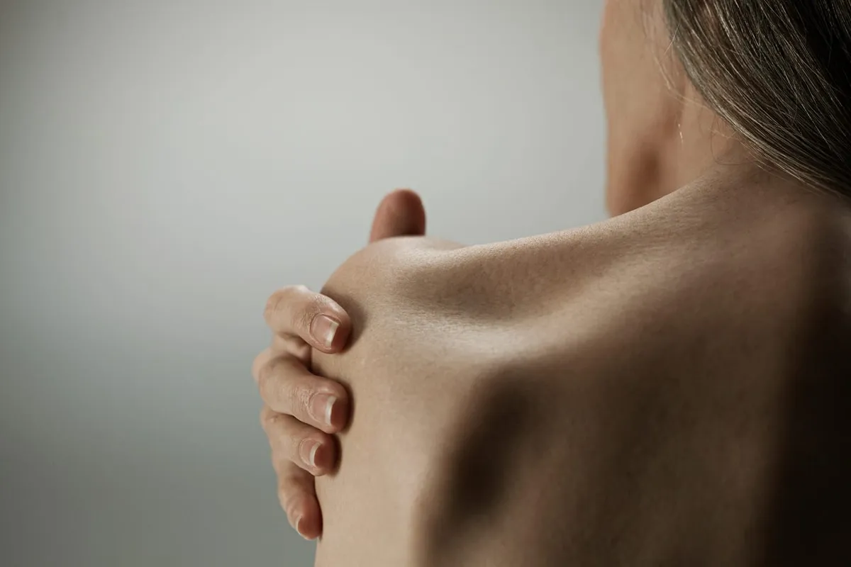 Person holding a painful shoulder.